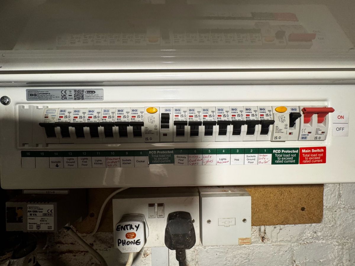 Dual-RCD consumer unit with neatly labelled circuits for sockets, lights, cooker and hob above a fused spur