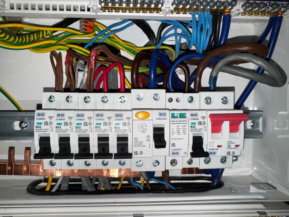 Inside a new consumer unit during installation, with live, neutral and earth conductors dressed to each breaker